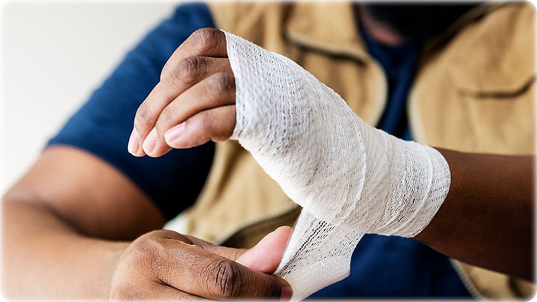 A person applying bandages to their hand